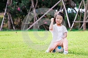 PortraitÃ¢â¬â¹ imageÃ¢â¬â¹ ofÃ¢â¬â¹ 4 yearsÃ¢â¬â¹ oldÃ¢â¬â¹ ofÃ¢â¬â¹ child.Ã¢â¬â¹ HappyÃ¢â¬â¹ Asian girl sitting on blue-white ball. photo